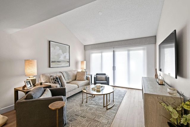 living room featuring a textured ceiling, hardwood / wood-style flooring, and vaulted ceiling