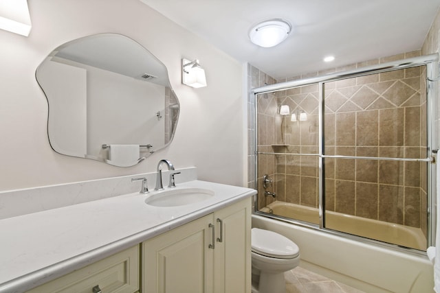 full bathroom featuring tile patterned floors, vanity, enclosed tub / shower combo, and toilet