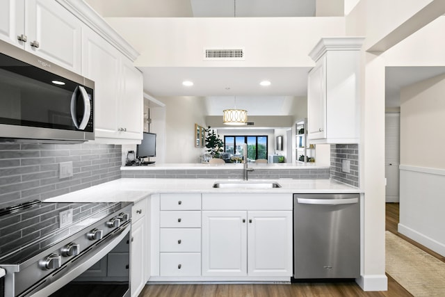 kitchen featuring white cabinets, decorative backsplash, stainless steel appliances, and sink