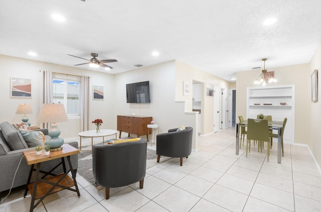 tiled living room with ceiling fan with notable chandelier