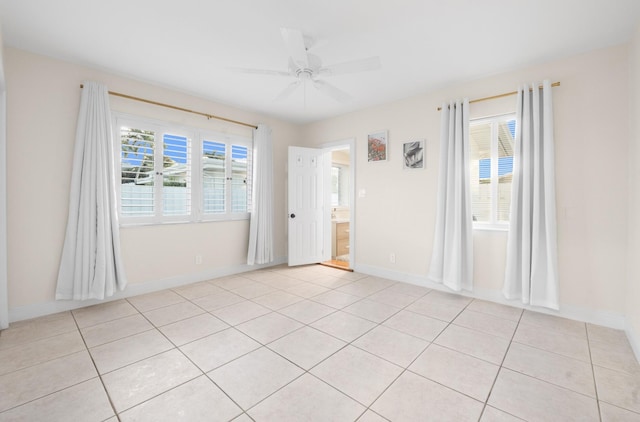 tiled spare room featuring ceiling fan