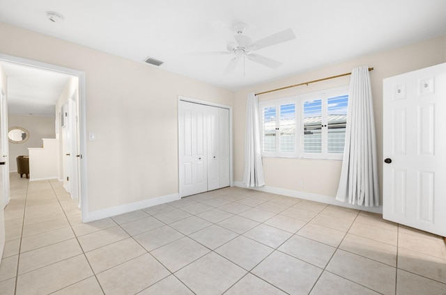 unfurnished bedroom with ceiling fan, a closet, and light tile patterned floors