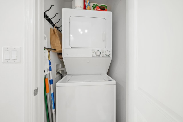 clothes washing area featuring stacked washer and clothes dryer