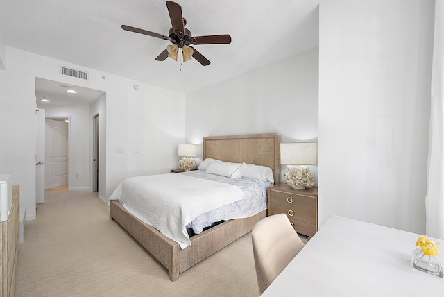 bedroom with light carpet, a textured ceiling, and ceiling fan