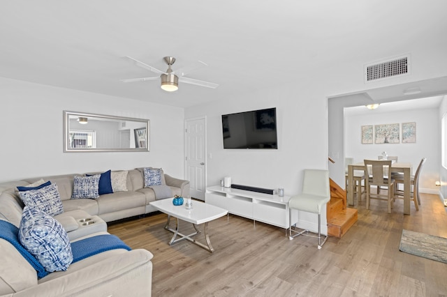 living room featuring hardwood / wood-style floors and ceiling fan