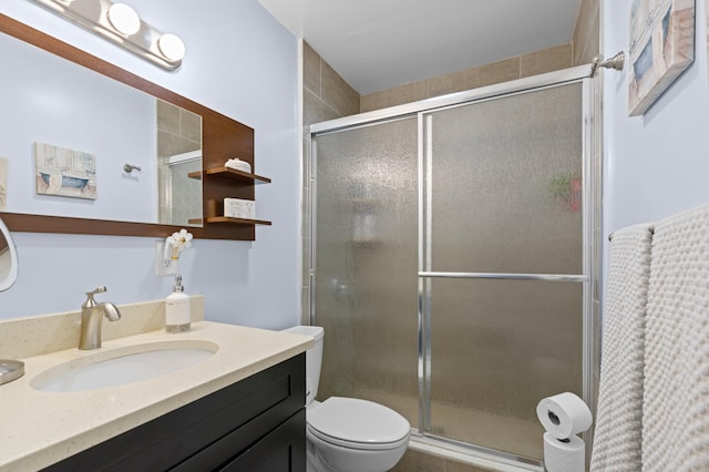 bathroom featuring vanity, toilet, and a shower with shower door