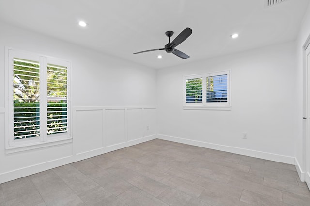 spare room featuring ceiling fan and a wealth of natural light