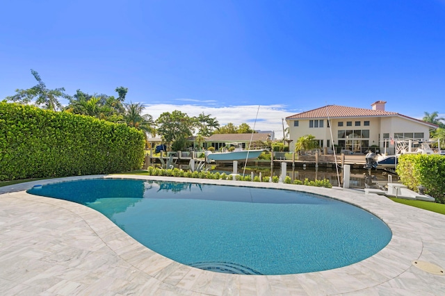 view of pool with a water view and a patio area