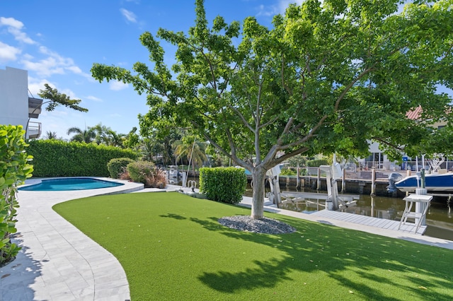 view of community featuring a lawn, a boat dock, a water view, and a swimming pool