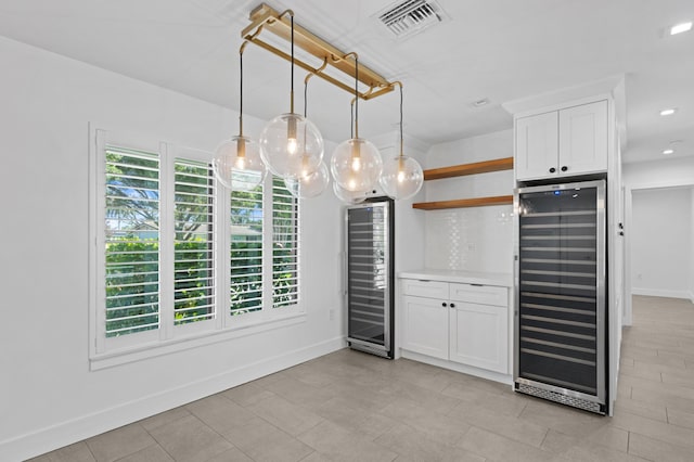 kitchen featuring a healthy amount of sunlight, wine cooler, and white cabinets