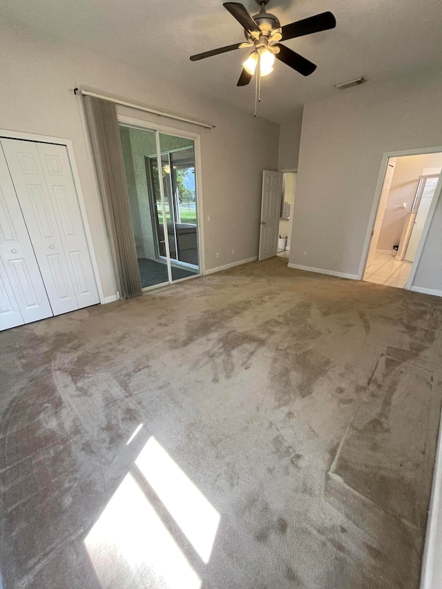 unfurnished bedroom featuring access to outside, carpet floors, and ceiling fan