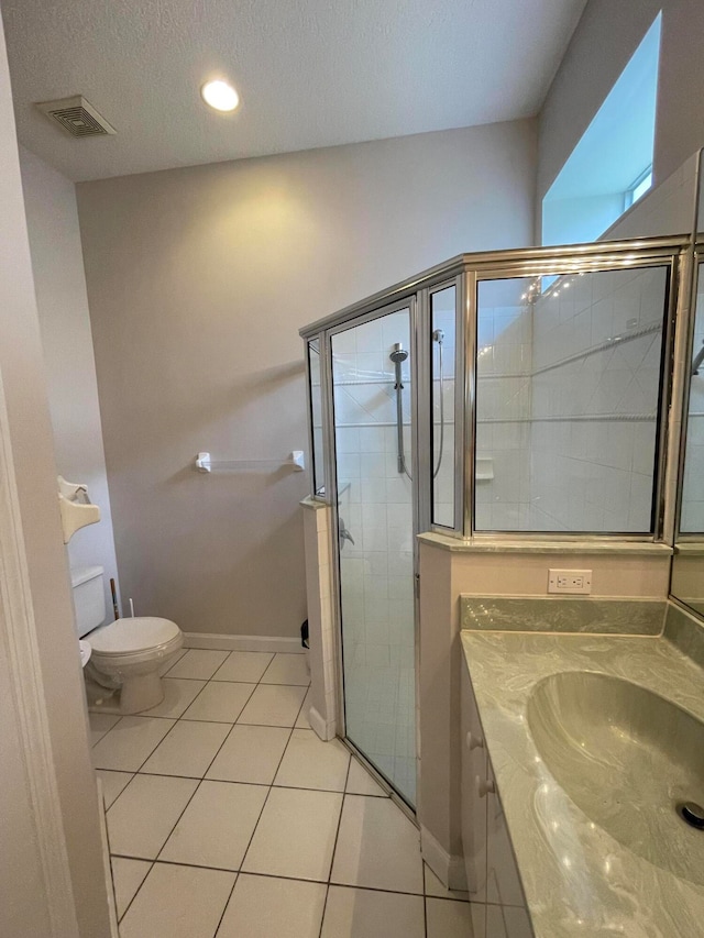 bathroom featuring tile patterned flooring, a textured ceiling, a shower with shower door, vanity, and toilet