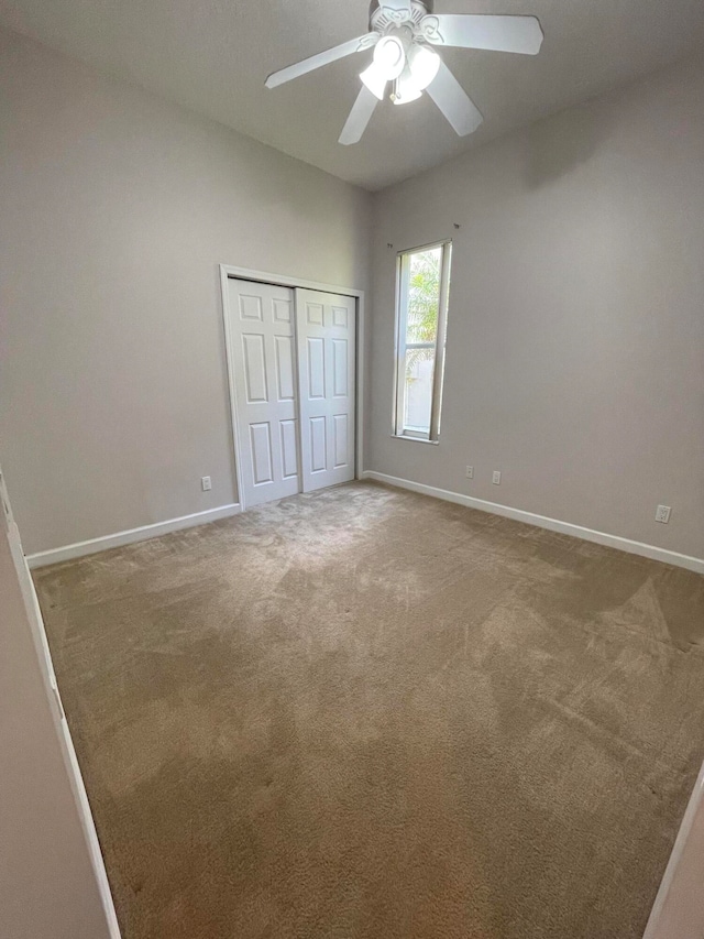 unfurnished bedroom featuring ceiling fan, carpet floors, and a closet