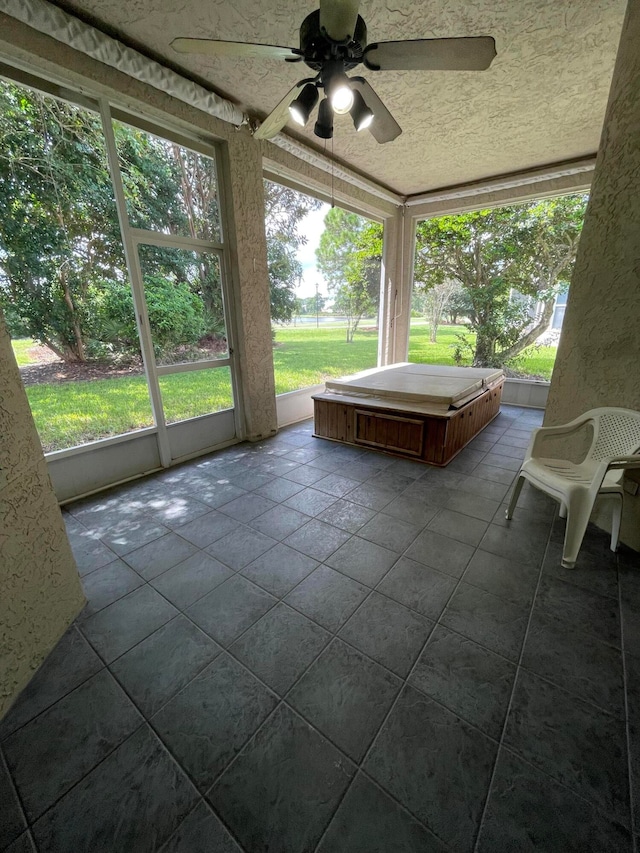 unfurnished sunroom featuring ceiling fan