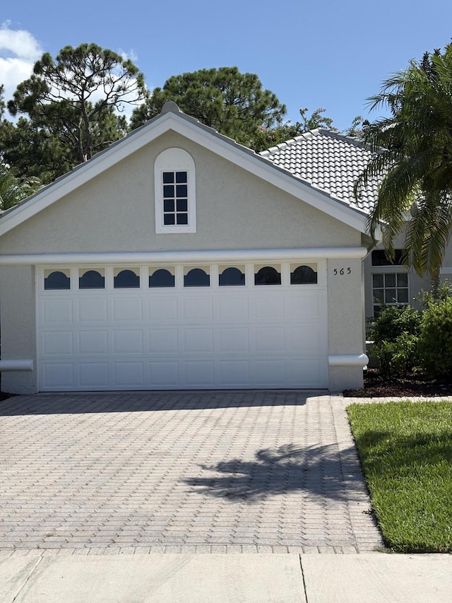 565 SW New Castle Cv, Port Saint Lucie, FL 34986 - view of front of house with stucco siding, driveway, and an attached garage