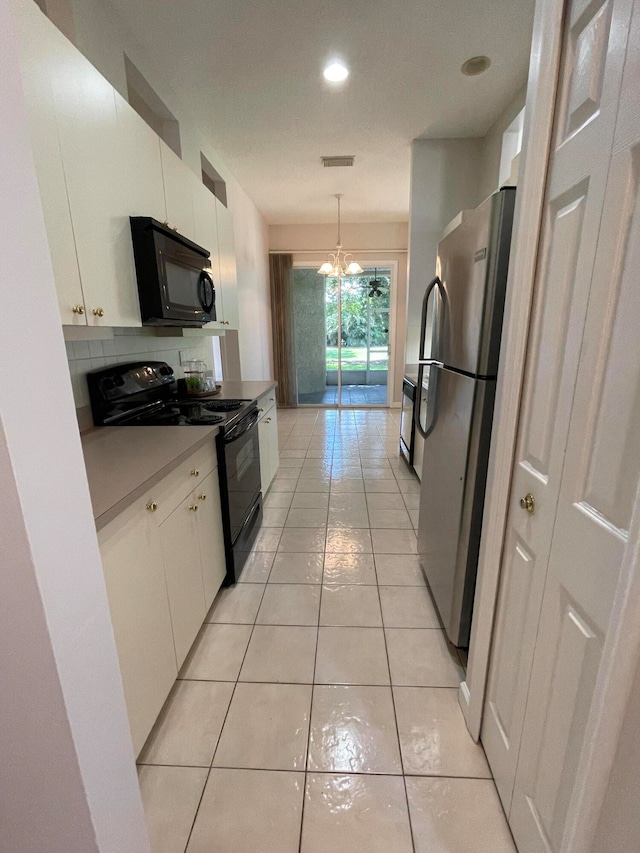 kitchen with black appliances, light tile patterned floors, white cabinetry, and hanging light fixtures