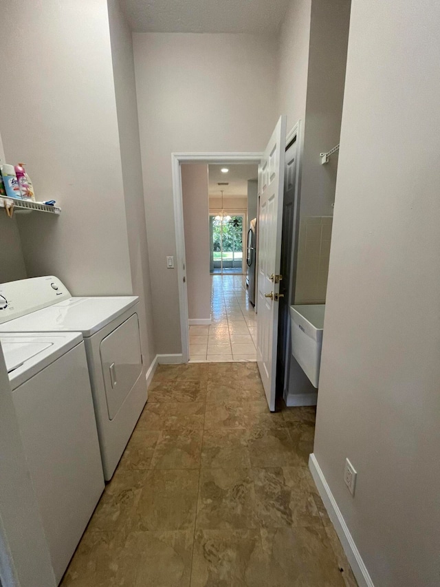 laundry area with independent washer and dryer and tile patterned floors