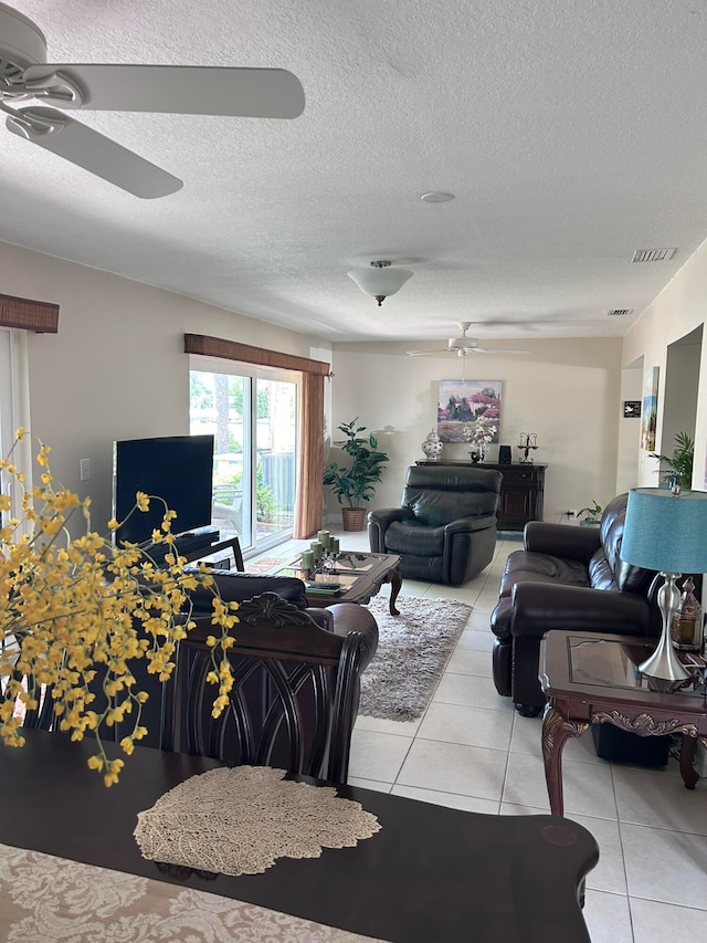 tiled living room featuring a textured ceiling and ceiling fan