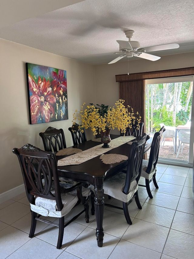 tiled dining room with ceiling fan and a textured ceiling