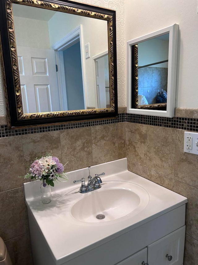 bathroom with vanity and tile walls