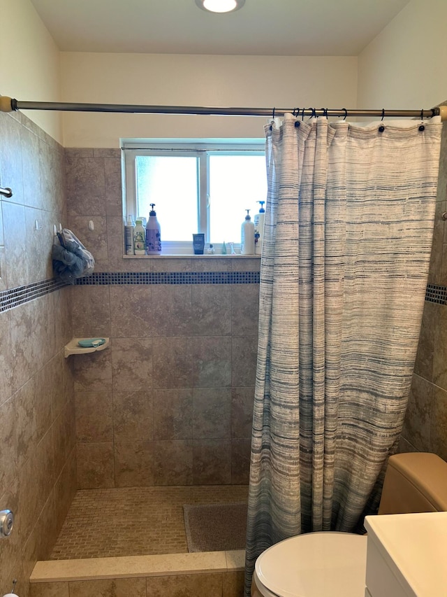 bathroom with curtained shower, vanity, and toilet