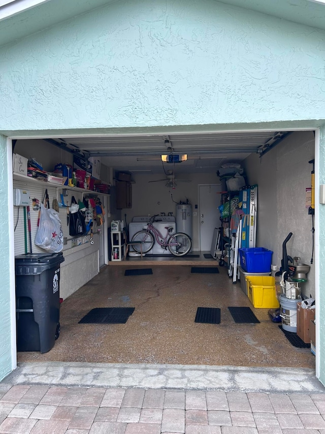 garage with a garage door opener, separate washer and dryer, and electric water heater