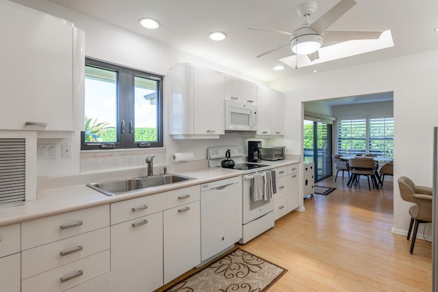 kitchen with white cabinets, plenty of natural light, white appliances, and sink