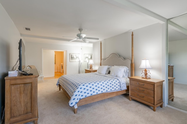 bedroom with light carpet, connected bathroom, and ceiling fan