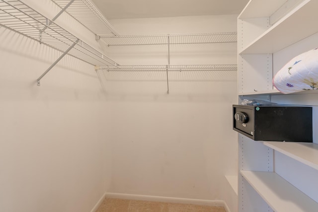 walk in closet featuring light colored carpet