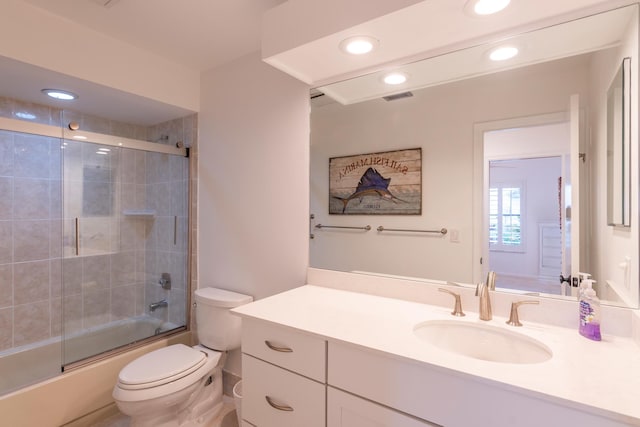 full bathroom with vanity, toilet, and bath / shower combo with glass door