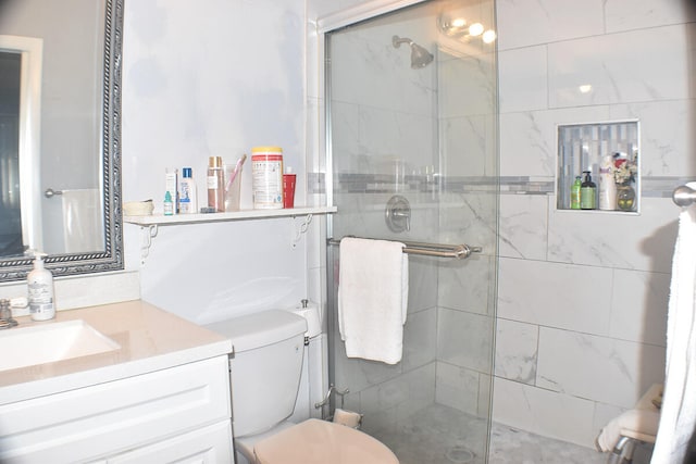 bathroom with vanity, a shower with shower door, and toilet