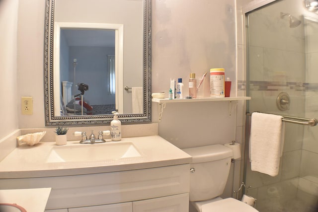 bathroom featuring vanity, toilet, and a shower with door