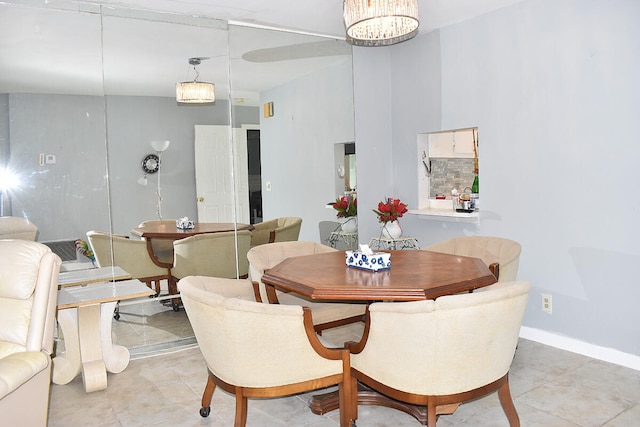 tiled dining room featuring an inviting chandelier