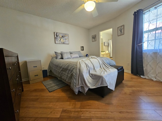 bedroom featuring a textured ceiling, connected bathroom, hardwood / wood-style floors, and ceiling fan