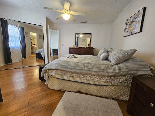 bedroom featuring a textured ceiling, hardwood / wood-style flooring, ceiling fan, and a closet