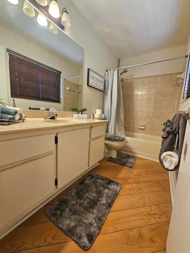 full bathroom with shower / tub combo with curtain, vanity, toilet, and hardwood / wood-style flooring