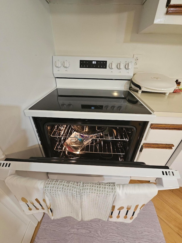 details with white range oven and wood-type flooring