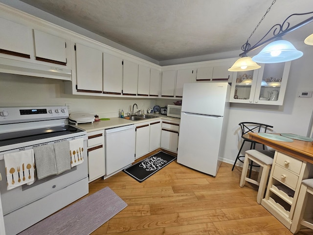 kitchen with light hardwood / wood-style floors, white appliances, pendant lighting, and white cabinets