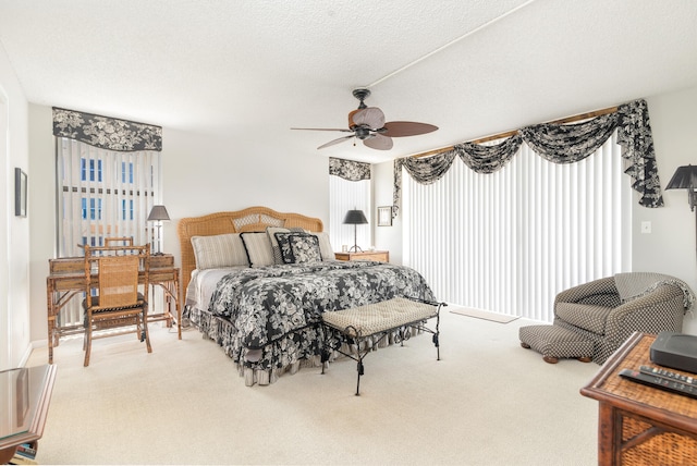 bedroom with a textured ceiling, carpet flooring, and ceiling fan