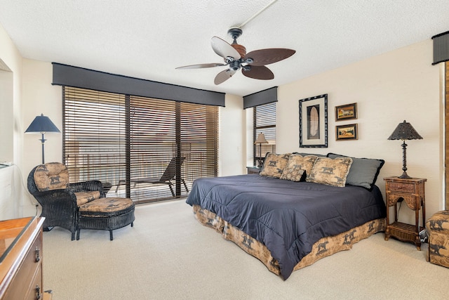 carpeted bedroom with ceiling fan, access to outside, and a textured ceiling