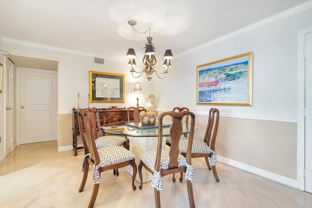 dining area featuring a notable chandelier, light wood-type flooring, a textured ceiling, and crown molding