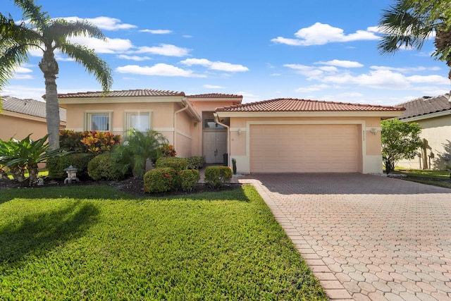 mediterranean / spanish-style home featuring a front yard and a garage