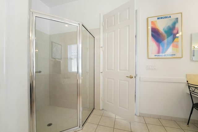 bathroom with a shower with shower door and tile patterned flooring