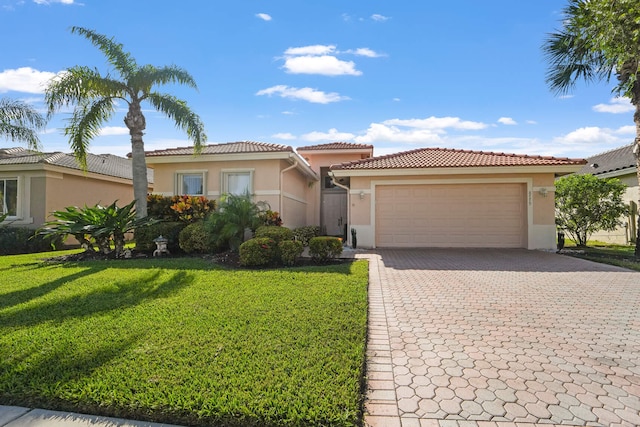 mediterranean / spanish-style home featuring a front lawn and a garage