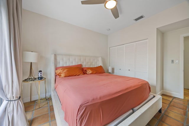 bedroom with ceiling fan, tile patterned floors, and a closet