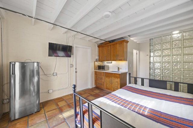 bedroom featuring sink, stainless steel fridge, and beam ceiling