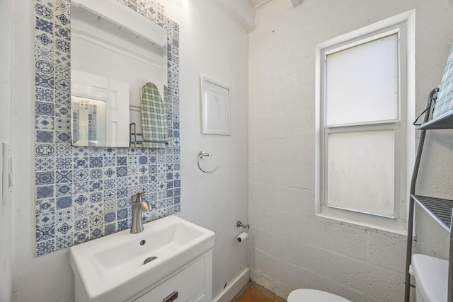 bathroom with vanity, toilet, and decorative backsplash