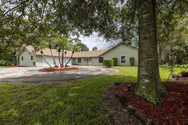 ranch-style home featuring driveway and a front lawn