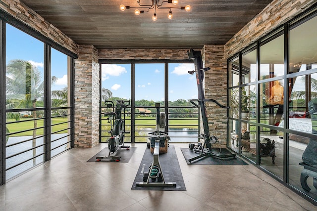 gym with a water view, plenty of natural light, and wooden ceiling