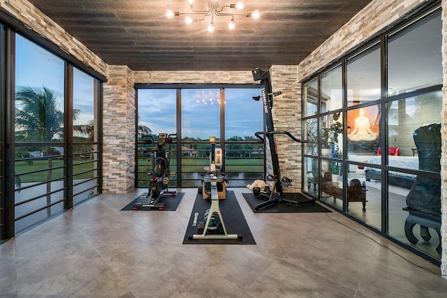 gym with concrete flooring, wooden ceiling, and a notable chandelier